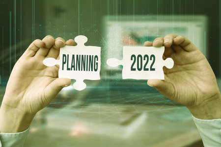 Text sign showing Planning 2022. Concept meaning process of making plans for something next year Business Woman Holding Jigsaw Puzzle Piece Unlocking New Futuristic Tech.の写真素材