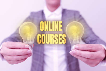 Sign displaying Online Courses. Conceptual photo Revolutionizing formal education Learning through internet Lady in business outfit holding two lamps presenting new technology ideasの写真素材