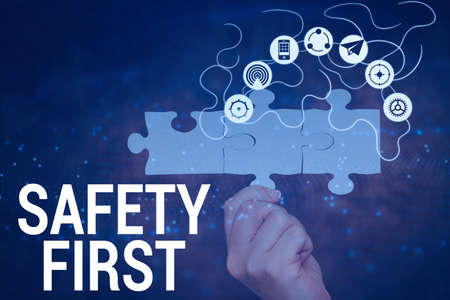 Handwriting text Safety First. Business showcase used to say that the most important thing is to be safe Hand Holding Jigsaw Puzzle Piece Unlocking New Futuristic Technologies.の写真素材