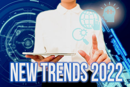 Text showing inspiration New Trends 2022. Business idea general direction in which something is developing Lady In Uniform Holding Phone Virtual Press Button Futuristic Technology.の写真素材