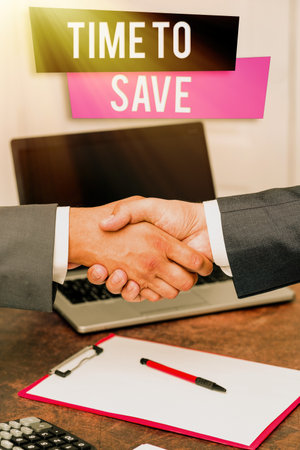 Text showing inspiration Time To Save. Word for to do something more efficiently that less time is required Two Professional Well-Dressed Corporate Businessmen Handshake Indoorsの写真素材