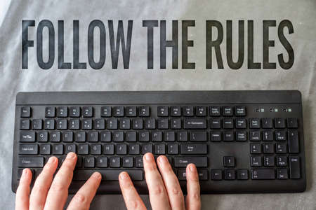 Writing displaying text Follow The Rules. Business overview go with regulations governing conduct or procedure Hands Pointing Pressing Computer Keyboard Enter Keys Typewriting New Ideas.の写真素材