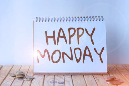 Sign displaying Happy Monday. Business concept telling that person order to wish him great new week Empty Open Spiral Notebook Beside Stockpile Of Coins On Top Of Desk.の写真素材