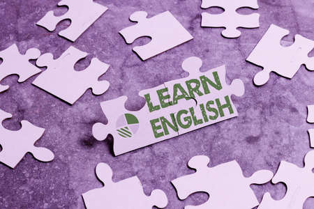 Writing displaying text Learn English. Business approach gain acquire knowledge in new language by study Building An Unfinished White Jigsaw Pattern Puzzle With Missing Last Pieceの写真素材
