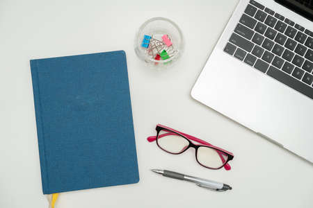 Office Supplies Over Desk With Keyboard And Glasses And Coffee Cup For Working Remotely, Assorted School Utilities For Studying With Hot Drink And Eyeglasses.の写真素材