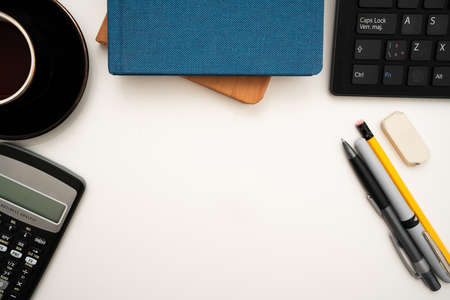 Office Supplies Over Desk With Keyboard And Glasses And Coffee Cup For Working Remotely, Assorted School Utilities For Studying With Hot Drink And Eyeglasses.の写真素材