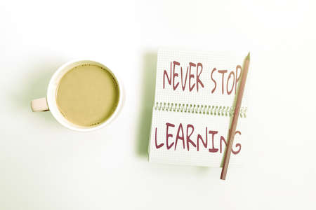 Hand writing sign Never Stop Learning. Business idea keep on studying gaining new knowledge or materials Display of Different Color Sticker Notes Arranged On flatlay Lay Backgroundの写真素材