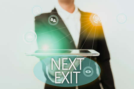 Text sign showing Next Exit. Business idea the following way out or act of leaving in a place or highway Lady In Suit Presenting Mobile Device With Futuristic Interface Tech.の写真素材