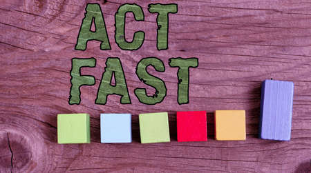 Text sign showing Act Fast. Word for Voluntarily move in the highest state of speed initiatively Stack of Sample Cube Rectangular Boxes On Surface Polished With Multi-Colourの写真素材