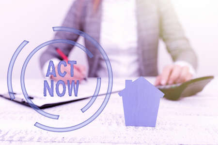 Conceptual caption Act Now. Business showcase do not hesitate and start working or doing stuff right away A Young Lady Orbusiness-Woman Calculating Orsigning Loans Ormortagages Orexpencesの写真素材