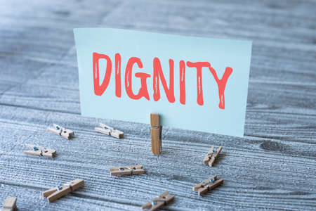 Conceptual caption Dignity. Business concept Quality Being worthy of honor respect Serious manner style Piece Of Blank Square Note Surrounded By Laundry Clips Showing New Idea.の写真素材