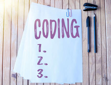 Conceptual display Coding. Business approach assigning code to something for classification identification Office Stationery Paper Clipped Together Laying Flat On Table.の写真素材