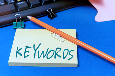 Hand writing sign Keywords. Word Written on word which acts as the key to a code Concept of great significance Multiple Assorted Collection Office Stationery Photo Placed Over Tableの写真素材