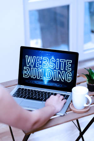 Handwriting text Website Building. Business showcase tools that typically allow the construction of pages Hand Busy Typing On Laptop Beside Coffe Mug And Plant Working From Home.の写真素材