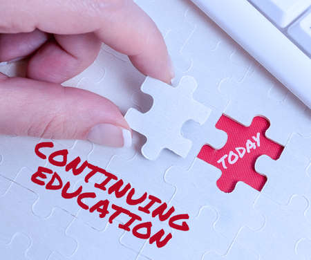 Text caption presenting Continuing Education. Business showcase Continued Learning Activity professionals engage in Building An Unfinished White Jigsaw Pattern Puzzle With Missing Last Pieceの写真素材