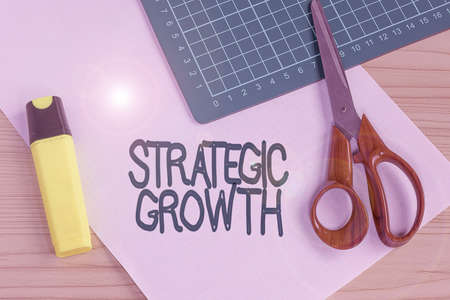 Hand writing sign Strategic Growth. Business concept create plan or schedule to increase stocks or improvement Multiple Assorted Collection Office Stationery Photo Placed Over Tableの写真素材