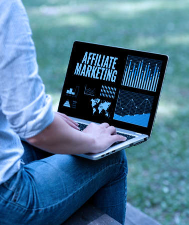 Inspiration showing sign Affiliate Marketing. Internet Concept Promoting another persons product Earning a Commission Woman Typing On Laptop Sitting Outside Side View Working From Home.の写真素材