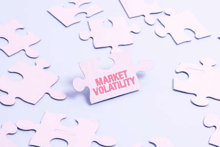 Hand writing sign Market Volatility. Business approach Underlying securities prices fluctuates Stability status Building An Unfinished White Jigsaw Pattern Puzzle With Missing Last Pieceの写真素材