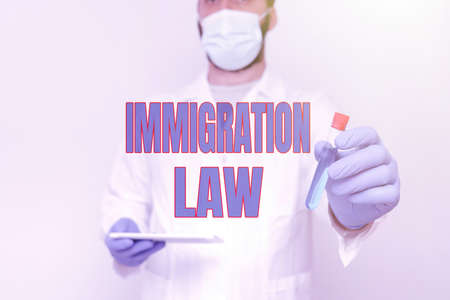 Text showing inspiration Immigration Law. Business idea Emigration of a citizen shall be lawful in making of travel Researcher Displaying Liquid Sample, Chemist Presenting Cleaning Agentの写真素材