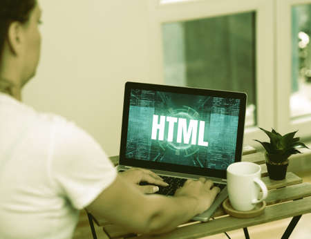 Inspiration showing sign Html. Business overview the lingua franca for publishing hypertext on the World Wide Web Woman Doing Work On Laptop Next To Plant And Mug Working From Home.の写真素材