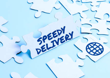 Sign displaying Speedy Delivery. Conceptual photo provide products in fast way or same day shipping overseas Building An Unfinished White Jigsaw Pattern Puzzle With Missing Last Pieceの写真素材