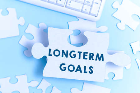 Handwriting text Longterm Goals. Business concept Strategic target that is required more time for completion Building An Unfinished White Jigsaw Pattern Puzzle With Missing Last Pieceの写真素材