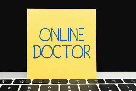 Writing displaying text Online Doctor. Business overview health practitioners deliver services over the internet Office Supplies Over Desk With Keyboard And Glasses And Coffee Cup For Workingの写真素材