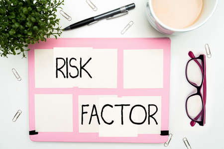 Hand writing sign Risk Factor. Business approach Characteristic that may increase the percentage of acquiring a disease Office Supplies Over Desk With Keyboard And Glasses And Coffee Cup For Workingの写真素材