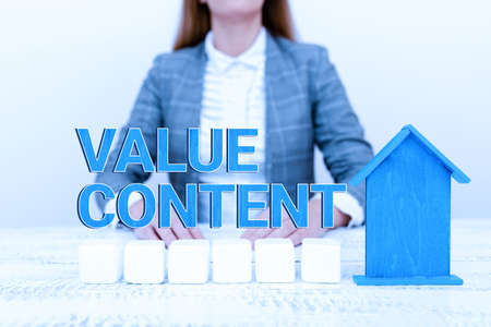Hand writing sign Value Content. Concept meaning exclusive details that a client cannot access anywhere A Young Lady Orbusinesswoman Holding Orpresenting Home In Business Outfitの写真素材