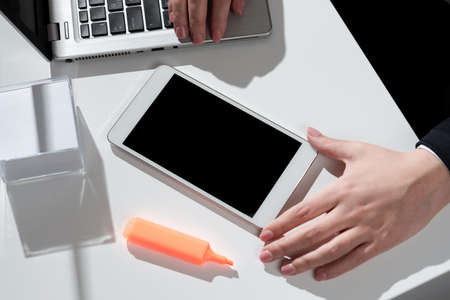 Businesswoman Presenting Important Message On Mobile Phone Screen On Desk With Notes, Marker And Lap...