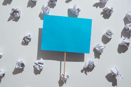 Wrinkled Notes Underneath Piece Of Paper With Important Message Glued On Stick. Crumpled Memos Placed Under Crutial Information Sticked To Wooden Rod.の写真素材