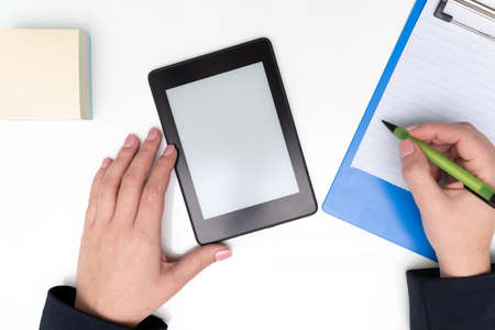 Tablet With Important Message On Desk With Sticky Notes And Clipboard. Woman Holding Pen And Writing...