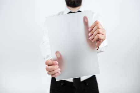 Male Professional Holding Blank Placard And Showing Important Data. Businessman With Paper In Hands...