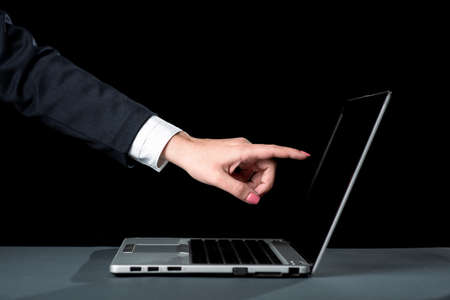Businesswoman Pointing Important Message On Lap Top Screen. Woman Showing Crutial Information On Computer. Lady In Suit Presenting Recent Announcements.の写真素材