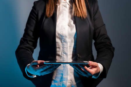 Businesswoman Holding Tablet With Important Message On It. Woman In Office Having Phone Screen With Crutial Informations. Executive Presenting Critical New On Cellphone.の写真素材