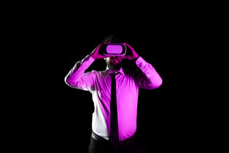 Bearded Businessman Using Virtual Reality Goggles And Taking Professional Training. Light Falling On...