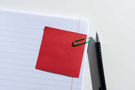Sticky Note With Important Message Clipped On Opened Notebook On Desk With Pen. Crutial Information...