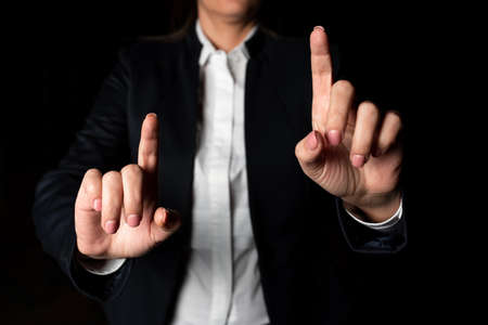 Businesswoman Pointing With Two Fingers On Important Messages. Executive In Suit Presenting Different Crutial Information. Woman Showing Critical Announcements.の写真素材