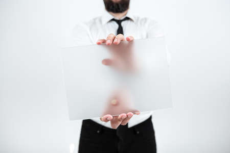 Male Professional Holding Blank Placard And Presenting Important Data. Man Wearing Necktie With Paper Displaying Marketing Strategies For Development Of Business.の写真素材
