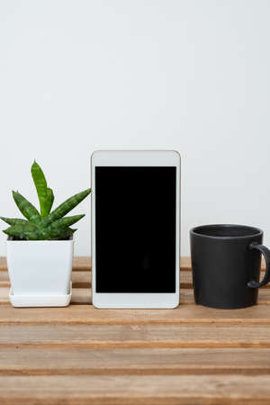 Tablet With Important Informations On Table With Plant And Cup Of Coffee. Crutial Announcements...