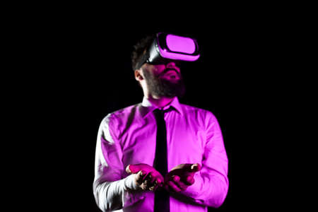 Bearded Businessman Wearing Virtual Reality Goggles And Enjoying Simulator. Light Falling On Man...