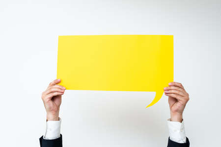 Businessman Holding Speech Bubble With Important Messages. Man In Suit Presenting Crutial Informations On Dialogue Balloon. Gentleman Showing Recent Updates On Paper.の写真素材