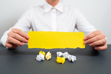 Businesswoman Holding Note With Important Message On Office Desk With Paper Wraps. Woman Presenting Crutial Information. Executive Showing Critical Data.の写真素材