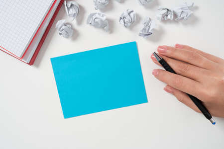 Businesswoman Holding Pen And Presenting Important Message On Note. Woman Showing Crutial Information On Desk With Notebooks And Paper Wraps. Executive Displaying New Ideas.の写真素材