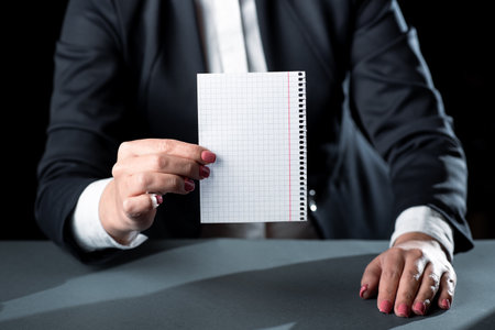 Businesswoman Holding Note With Important Message With One Hand. Woman Having Notebook With Crutial Information. Executive Showing Critical Data On Paperの写真素材