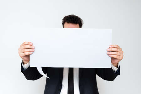 Businessman Holding Speech Bubble With Important Messages. Man In Suit Presenting Crutial...