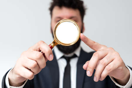 Businessman Holding Magnifier In One Hand. Man Having Magnifying Glass To Point Important...