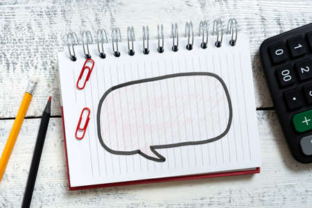 Speech Bubble With Important Messages Written On Notebook On Floor With Pencils, Clips And Calculator Around. New Ideas In Dialogue Balloon On Notepad On Ground.の写真素材