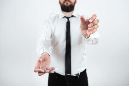 Male Corporate Holding Transparent Glass And Presenting Important Sales Data. Businessman Wearing Necktie Displaying New Ideas And Strategies For The Marketing.の写真素材