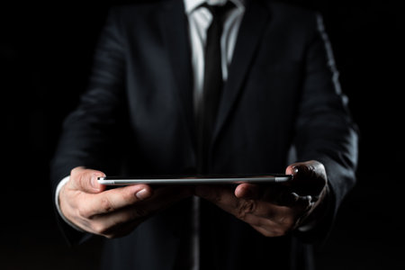 Businessman Holding Tablet With Both Hands And Presenting Important Data. Man In Suit Showing Crutial Information. Executive Displaying Crutial Announcement.の写真素材